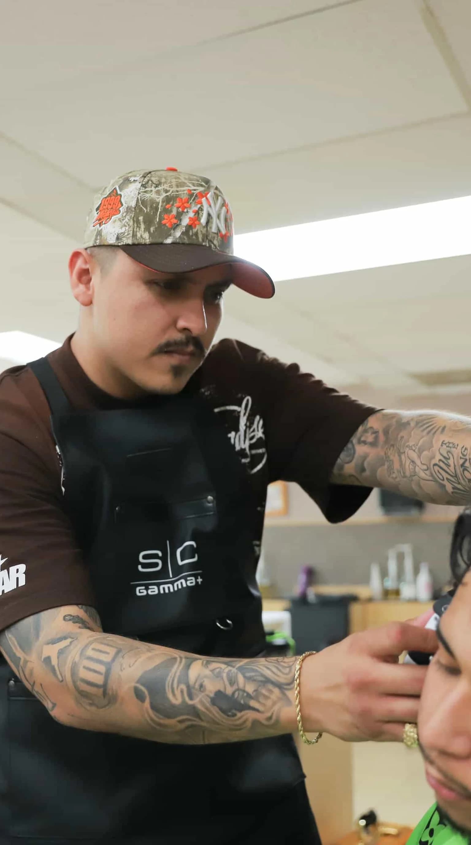 Young barber with clippers in modern shop