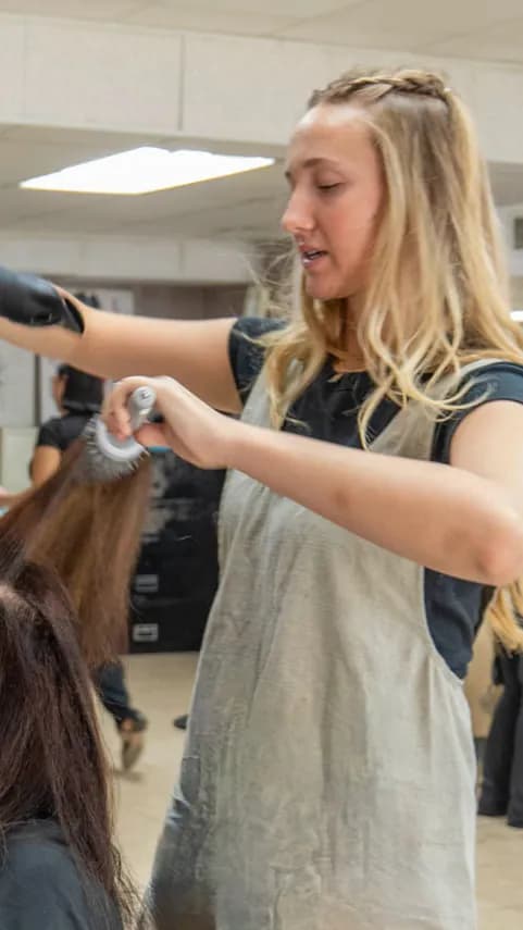 Hairstylist applying balayage color in bright salon