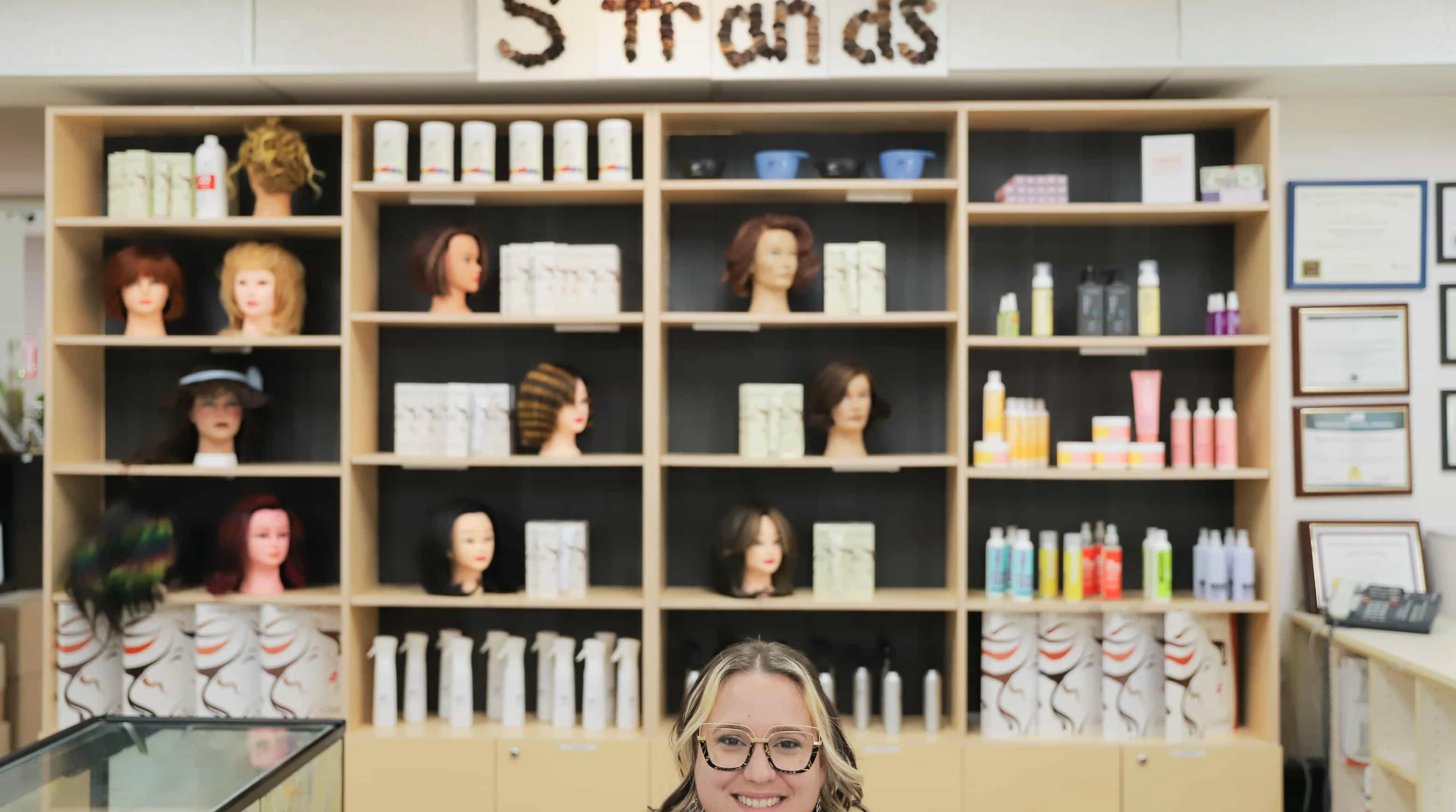 Stylist blow drying client hair in warm salon